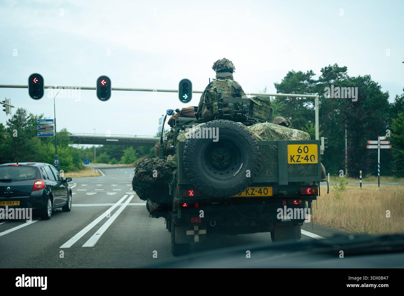 Veicolo militare olandese con soldati mimetizzati che guidano su una strada rurale vicino ad Arnhem, nei Paesi Bassi, durante un'esercitazione o una pattuglia. Foto Stock