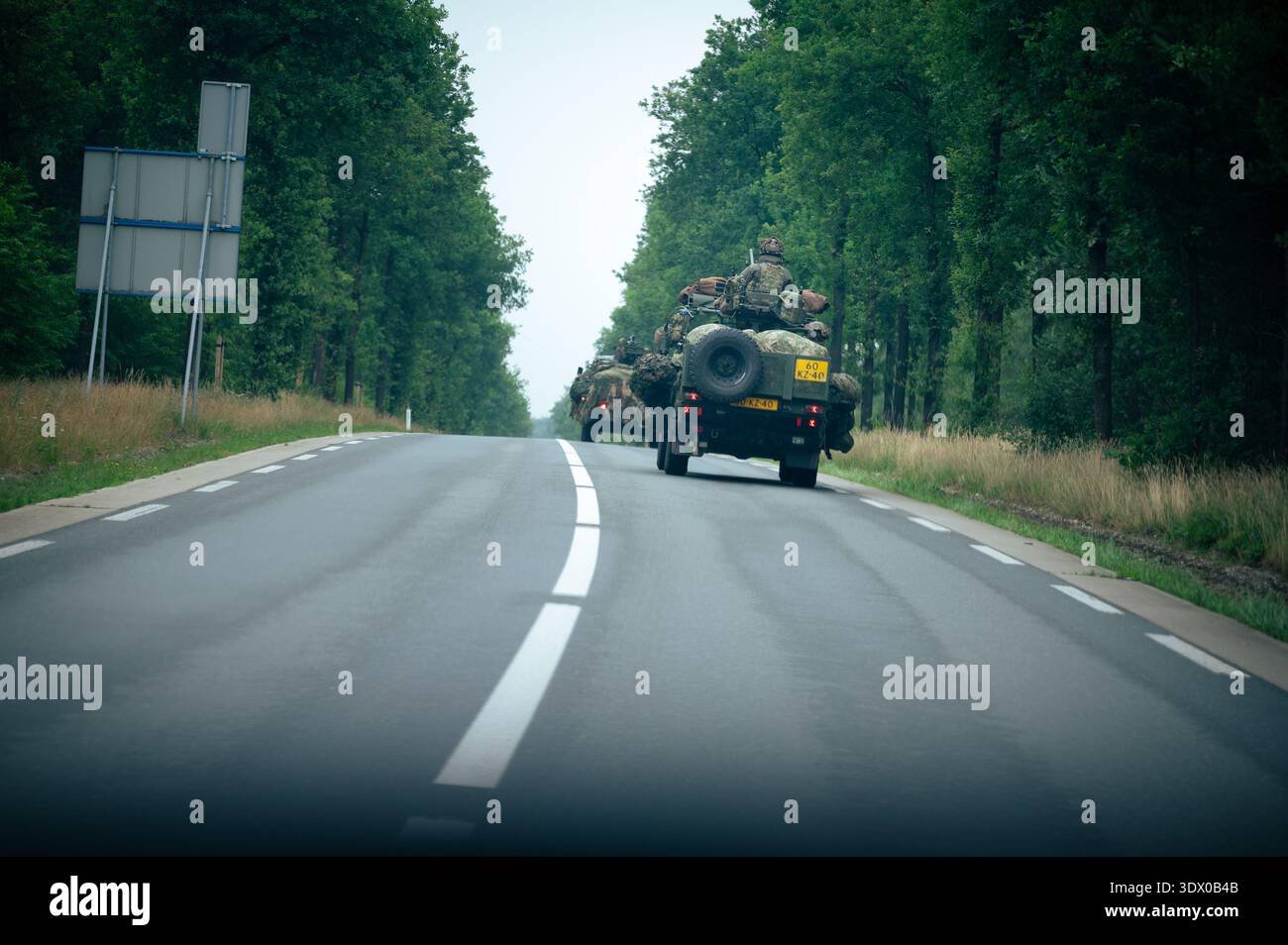 Veicolo militare olandese con soldati mimetizzati che guidano su una strada rurale vicino ad Arnhem, nei Paesi Bassi, durante un'esercitazione o una pattuglia. Foto Stock