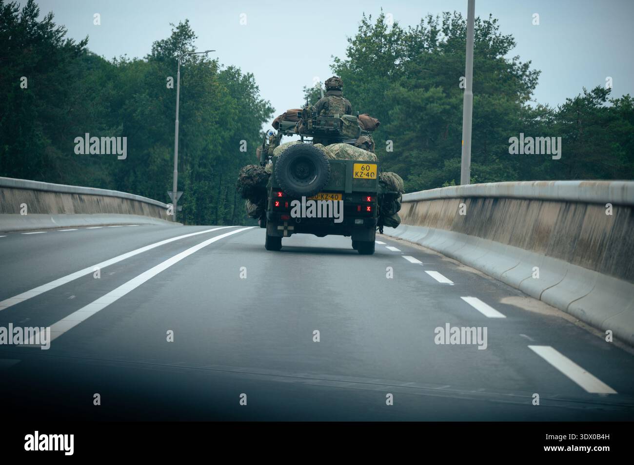 Veicolo militare olandese con soldati mimetizzati che guidano su una strada rurale vicino ad Arnhem, nei Paesi Bassi, durante un'esercitazione o una pattuglia. Foto Stock