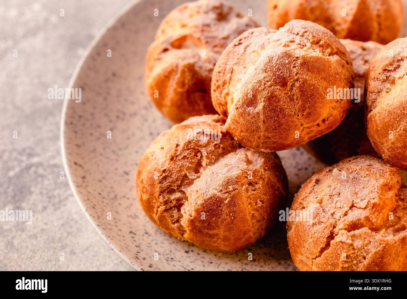 Profiteroles fatti in casa con zucchero a velo. Foto Stock
