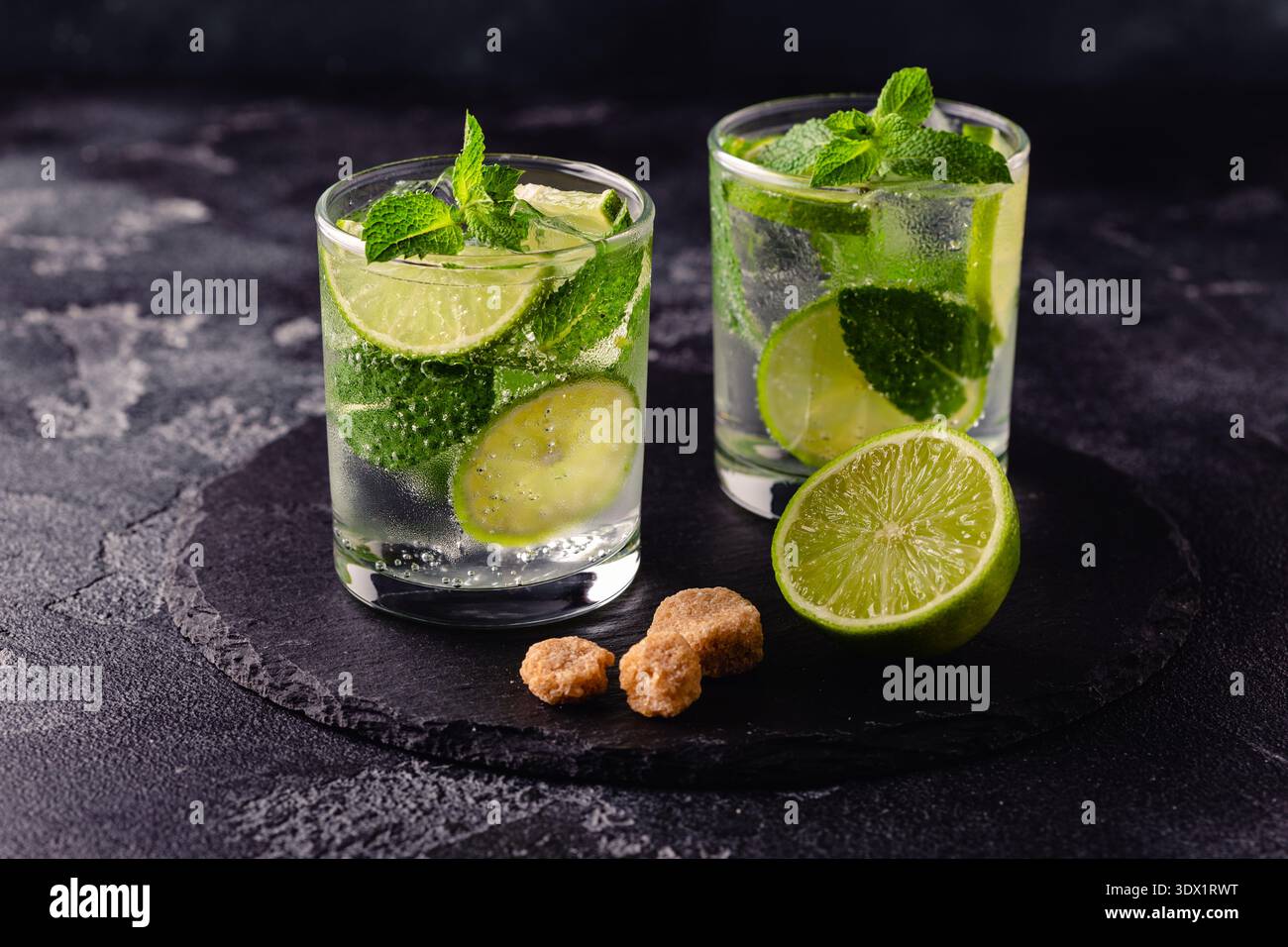 Cocktail analcolico estivo rinfrescante mojito con ghiaccio, menta fresca e lime, focus selettivo Foto Stock