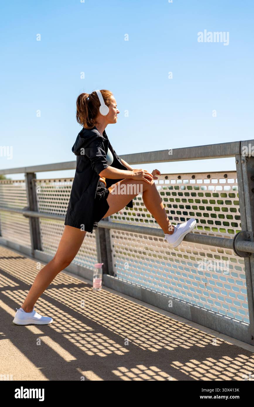 Concetto di jogging in città: Donna che si riscalda prima di allenarsi. Foto Stock