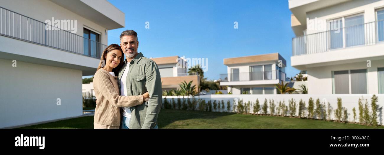 Ritratto dei proprietari di una coppia di famiglie felici e mature che si trovano fuori casa. Foto Stock