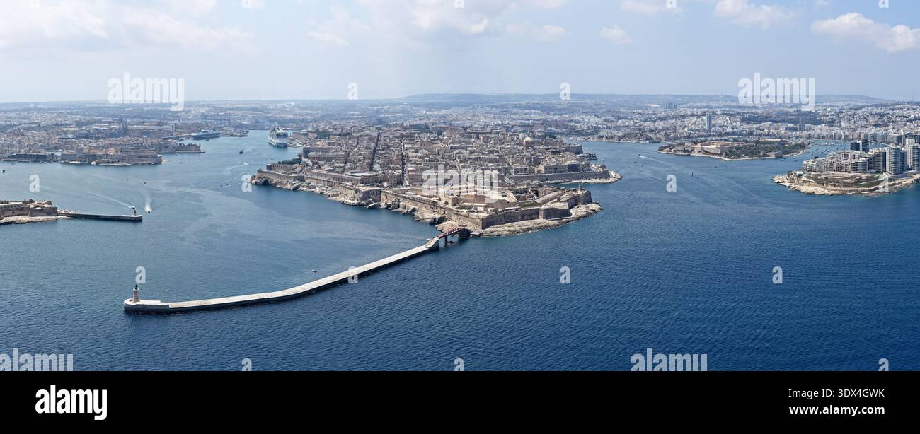 Panorama droni della penisola fortificata di Vallettas e ingresso al Grand Harbour, con frangiflutti, navi da crociera e fitti blocchi di pietra calcarea durante l'estate Foto Stock