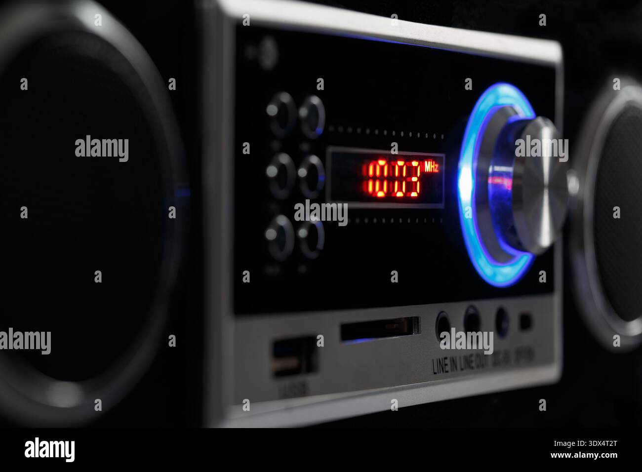 Una moderna radio stereo FM con display digitale e retroilluminazione luminosa. Vista laterale con toni scuri. Foto Stock