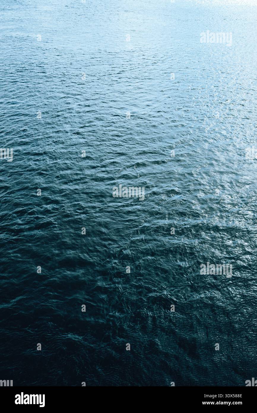Superficie d'acqua ondulata calma con onde delicate e riflessi morbidi, sfondo minimalista con texture naturale. Messa a fuoco selettiva. Foto Stock