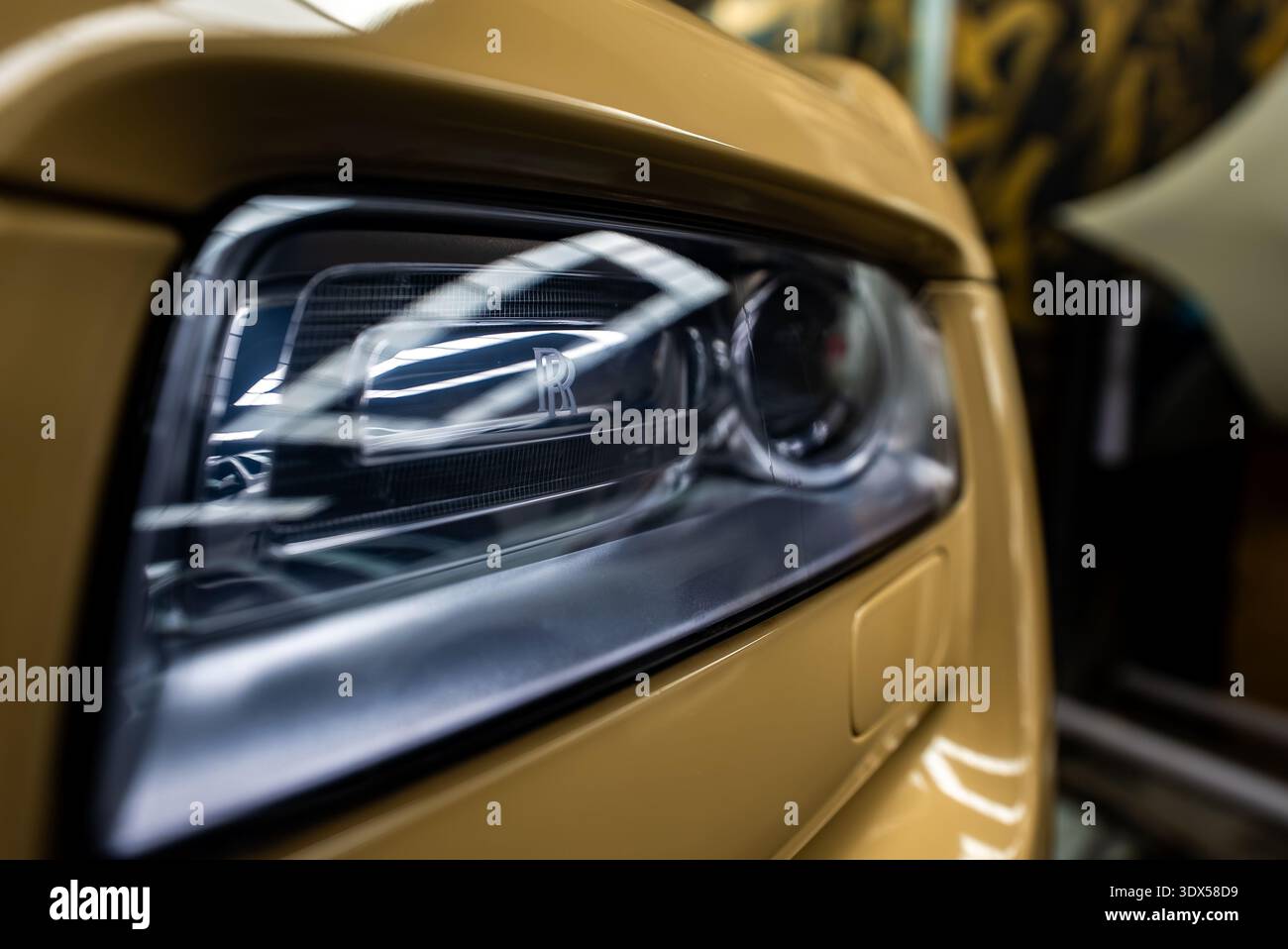 Faro sinistro Rolls Royce Phantom con monogramma RR sotto le luci per officina Foto Stock