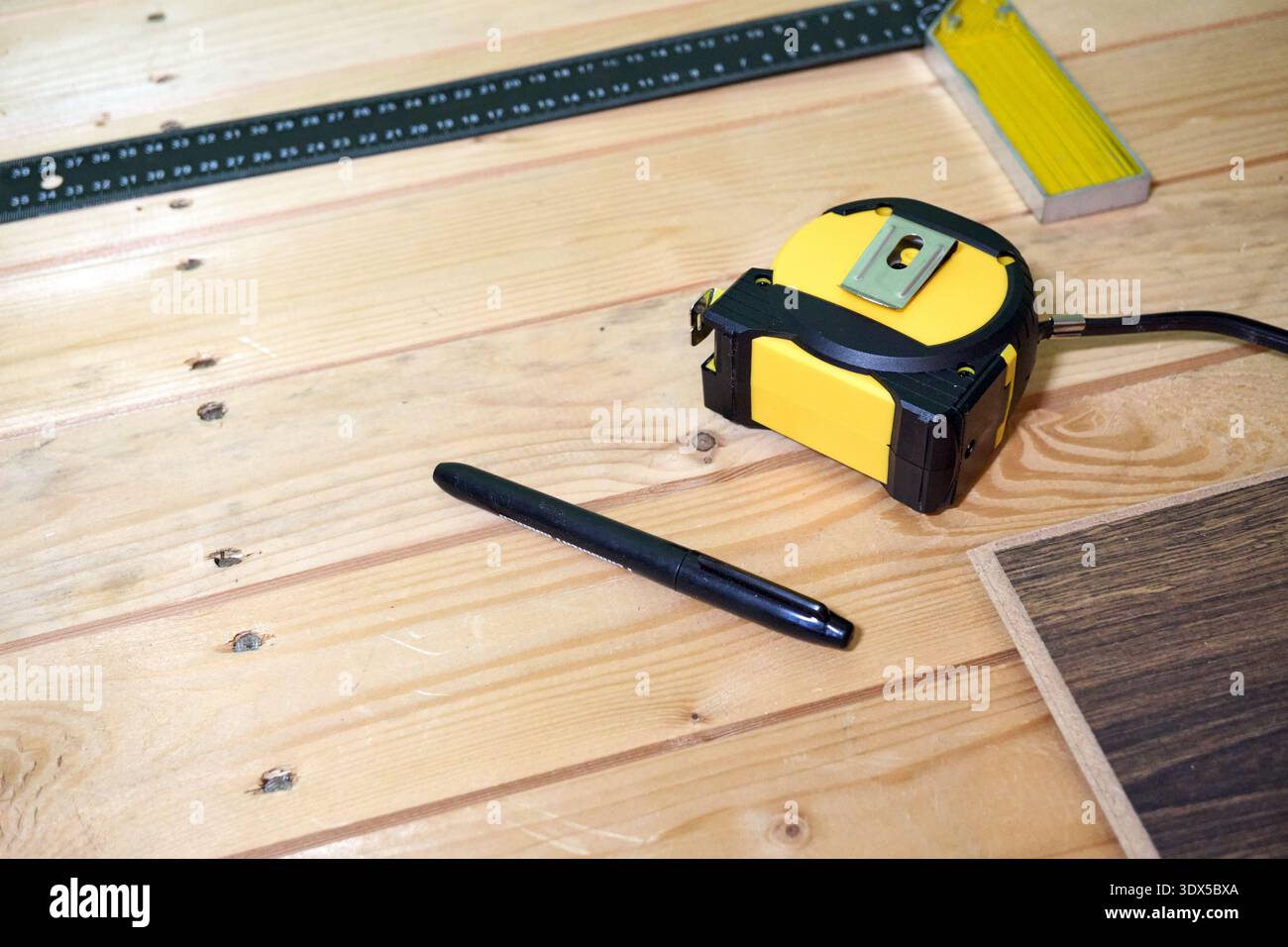 Strumenti di misurazione su superfici in legno: Metro a nastro, matita e righello per lavori di precisione Foto Stock