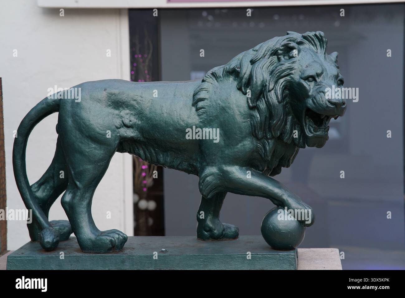 Statua di leone patinato in bronzo con zampa su sfera a Mentone. Mentone, Francia Foto Stock