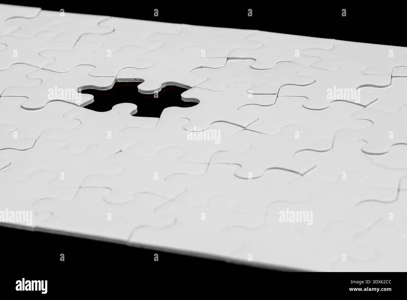 Puzzle di puzzle bianco con un pezzo mancante su sfondo nero Foto Stock