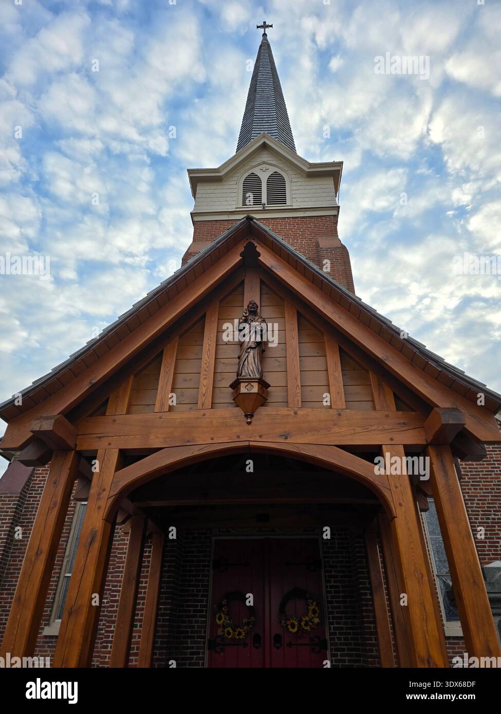 Chiesa episcopale di San Pietro con ingresso in legno e campanile sotto un cielo parzialmente nuvoloso a Lewes, Delaware. Novembre 2025. - Immagine stock catturata con smartphone