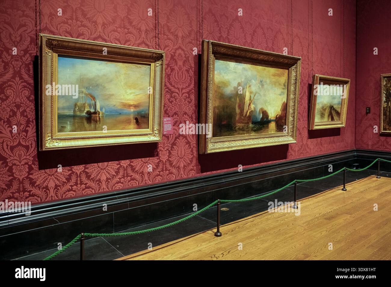 Londra, Regno Unito – Vista della sala Turner Collection nella National Gallery, con dipinti ad olio marittimi di J.M.W. Turner su carta da parati rossa damascata Foto Stock