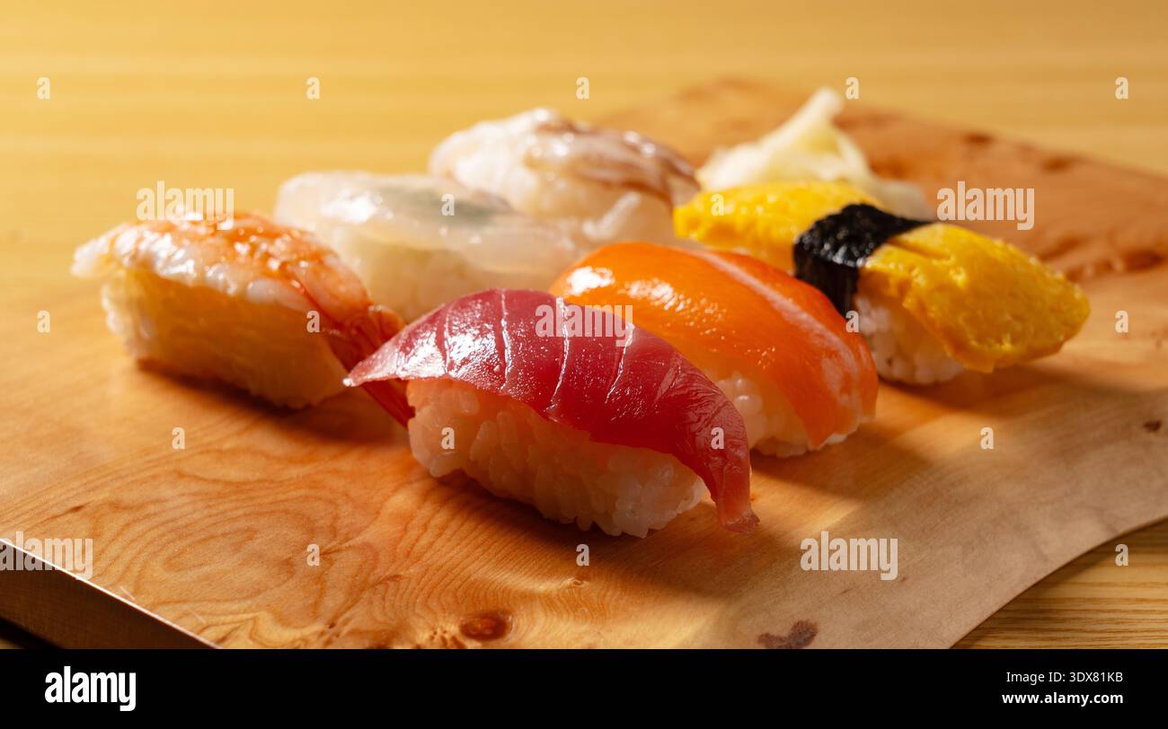 Assortimento di sushi nigiri freschi su un asse di legno Foto Stock