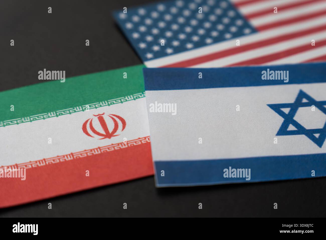 Le bandiere di Israele, Stati Uniti e Iran si sovrappongono su una superficie scura. Tensioni militari tripartite, guerra regionale in Medio Oriente e geopolitica Foto Stock