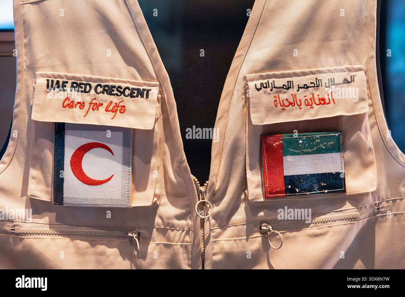 6 dicembre 2025, Abu Dhabi, Emirati Arabi Uniti: Gilet rosso Mezzaluna con loghi ricamati, tra cui Care for Life e simbolo rosso Mezzaluna Foto Stock
