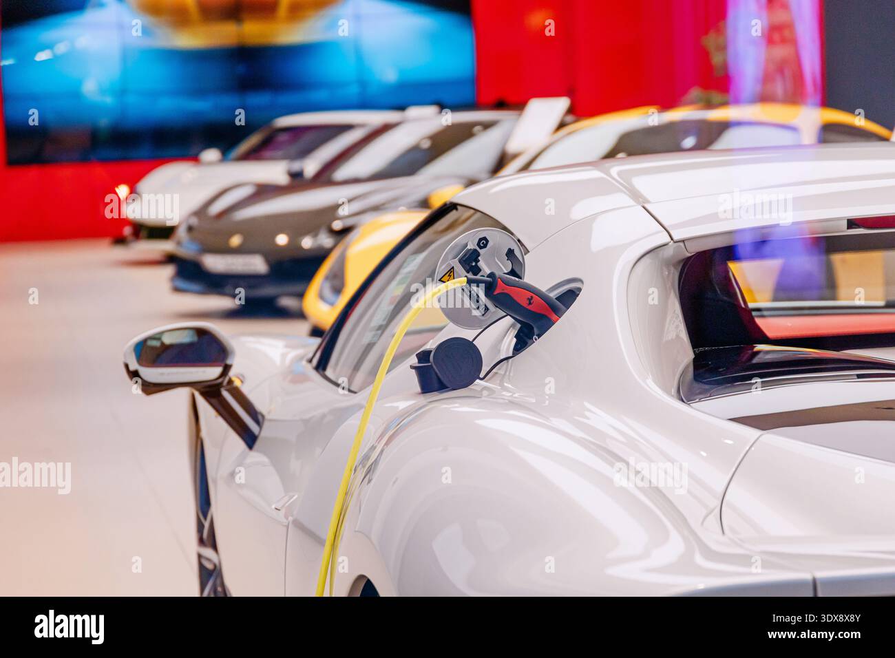 30 novembre 2025, Doha, Qatar: Collegamento di ricarica Ferrari per auto sportive elettriche presso una concessionaria, simbolo della moderna tecnologia automobilistica Foto Stock