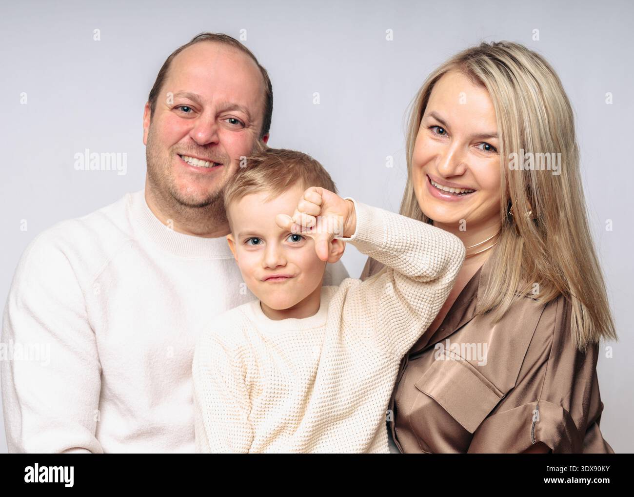 Famiglia europea felice con figlio di 4 anni, studio girato dalla vita alla vita, vestito con colori beige su sfondo bianco, tutti genitori biondi 35-39 anni Foto Stock