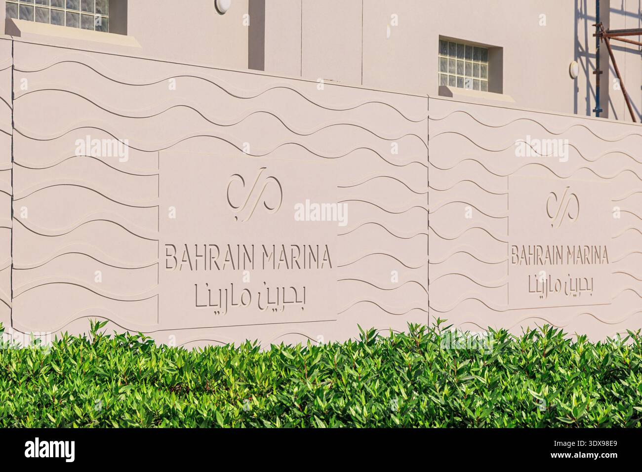 3 dicembre 2025, Bahrain, Manama: Facciata a muro con il suo logo, testo in inglese e arabo e motivo a onde Foto Stock
