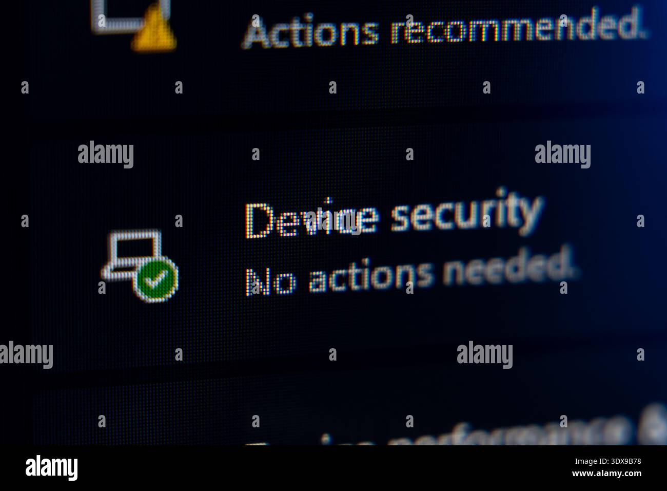 Primo piano di un'interfaccia di sicurezza di un dispositivo digitale che mostra un'icona con un segno di spunta verde e il messaggio che indica che il sistema è in buone condizioni e che non richiede alcuna azione Foto Stock