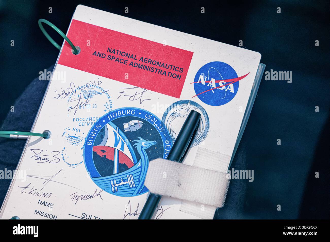 5 dicembre 2025, Abu Dhabi, Emirati Arabi Uniti: Quaderno con logo NASA, dettagli della missione SpaceX Crew 6, nome del sultano al Neyadi e firme dell'astronauta Foto Stock