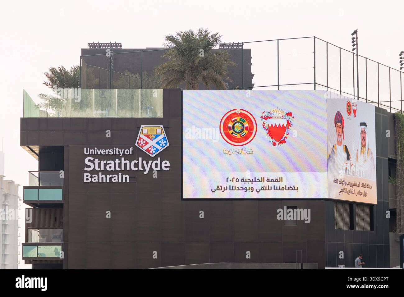 2 dicembre 2025, Bahrain, Manama: Moderno edificio universitario con il logo dell'Università di Strathclyde e una pubblicità del GCC Summit Foto Stock