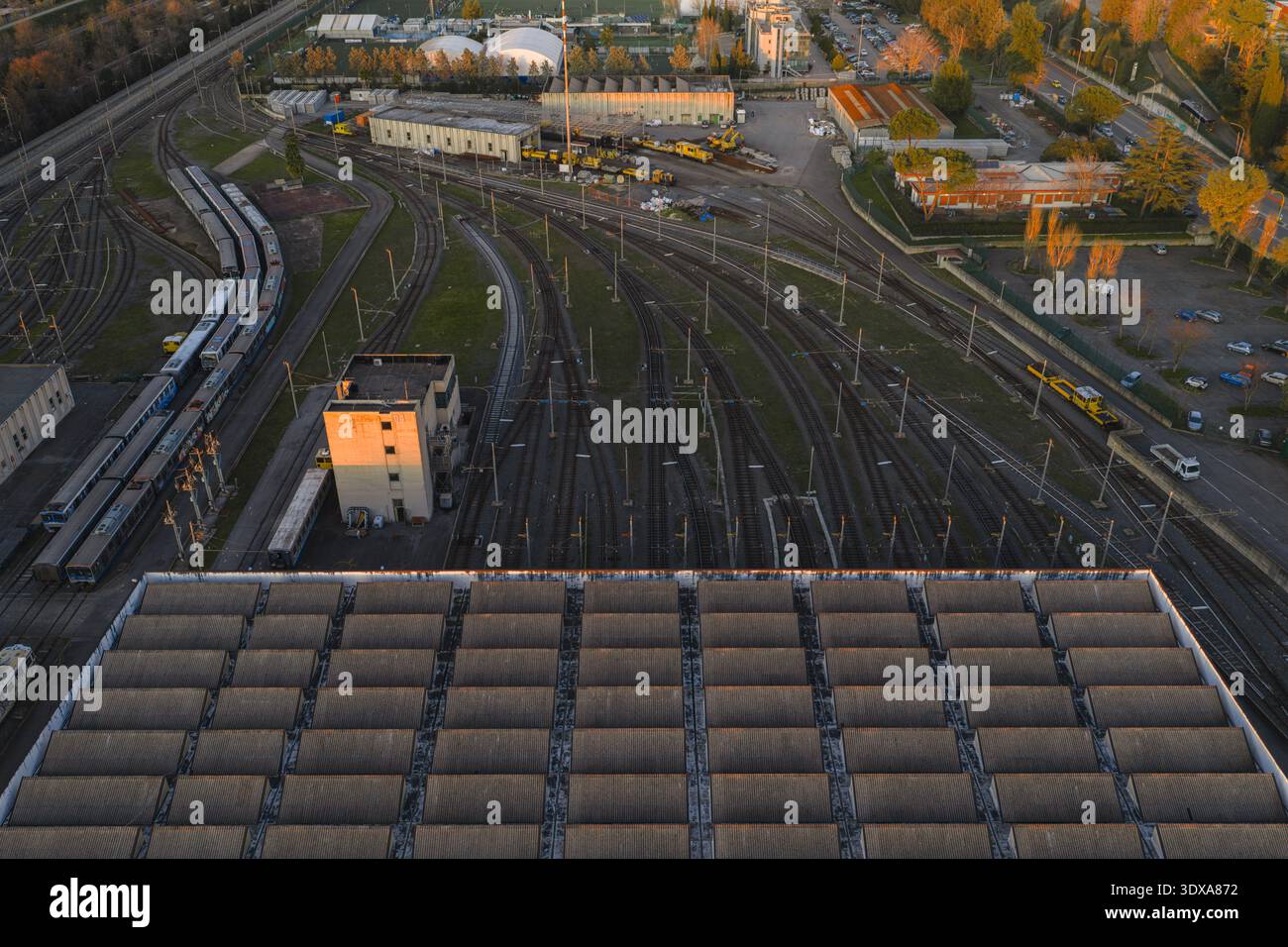 Vista aerea dei binari del treno che si snodano attraverso un complesso scalo ferroviario, un arazzo di acciaio che incontra la luce dorata del sole che tramonta, Roma, Lazio, Ital Foto Stock