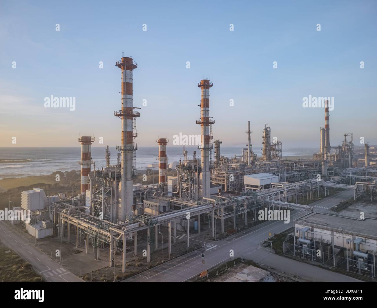 Vista aerea di strutture industriali in contrasto con le onde morbide dell'oceano, una sinfonia d'acciaio e l'abbraccio della natura, Matosinhos, quartiere di Porto, Foto Stock