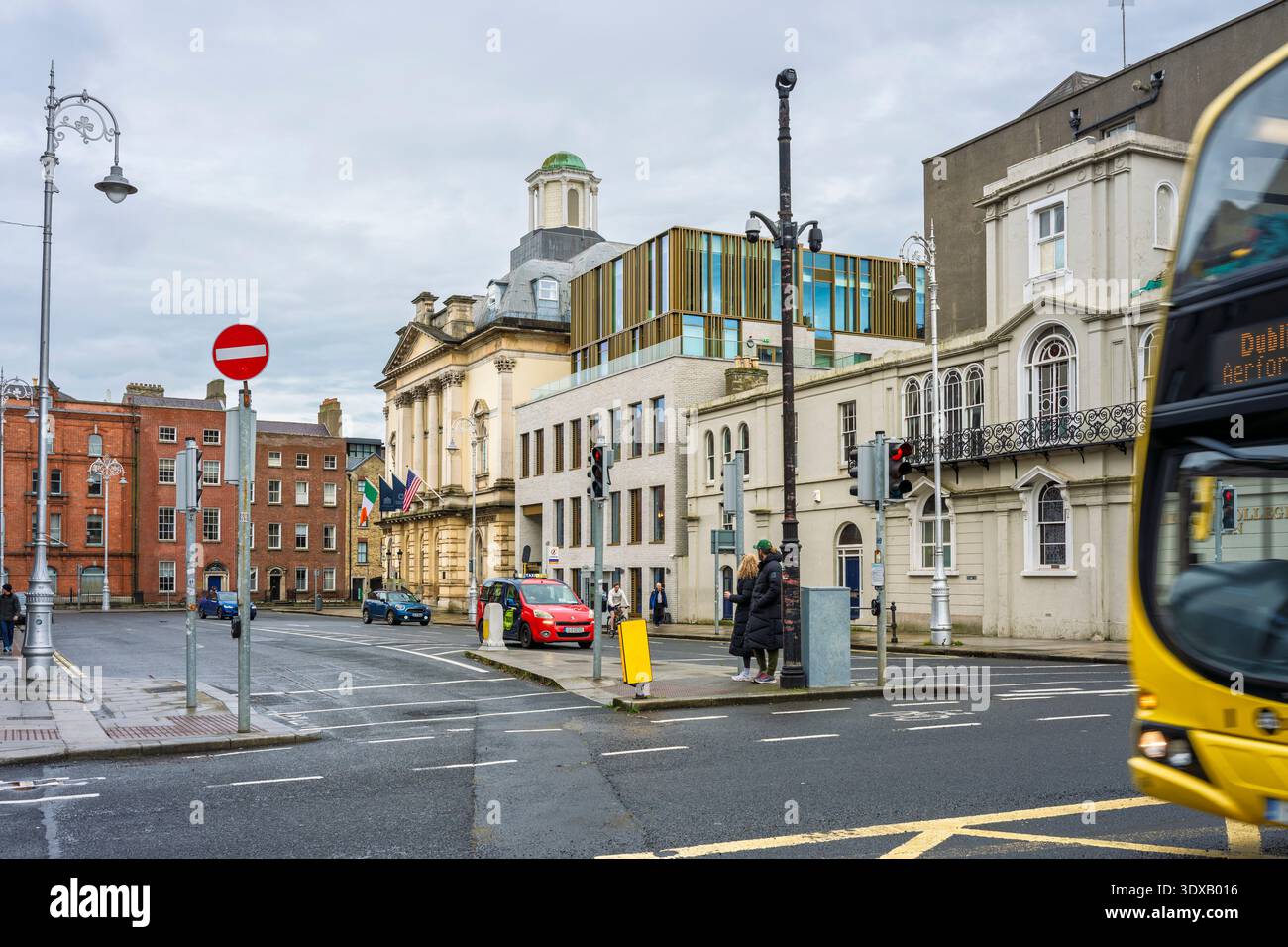 I livelli architettonici di Dublino. L'intersezione del centro di Dublino con l'architettura storica e moderna, autobus giallo in movimento Foto Stock