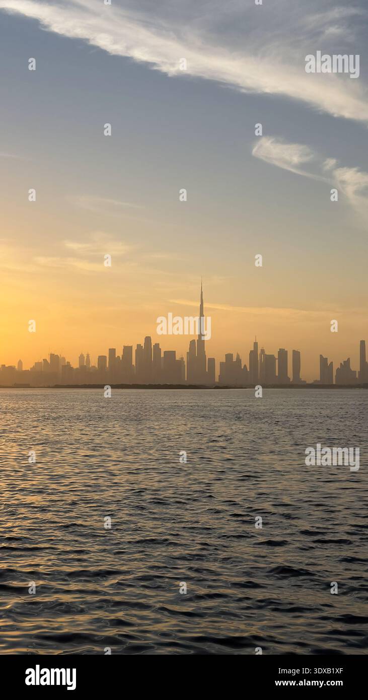 Vista dello skyline della città dal Dubai Creek Harbor su un tramonto di colore dorato Foto Stock