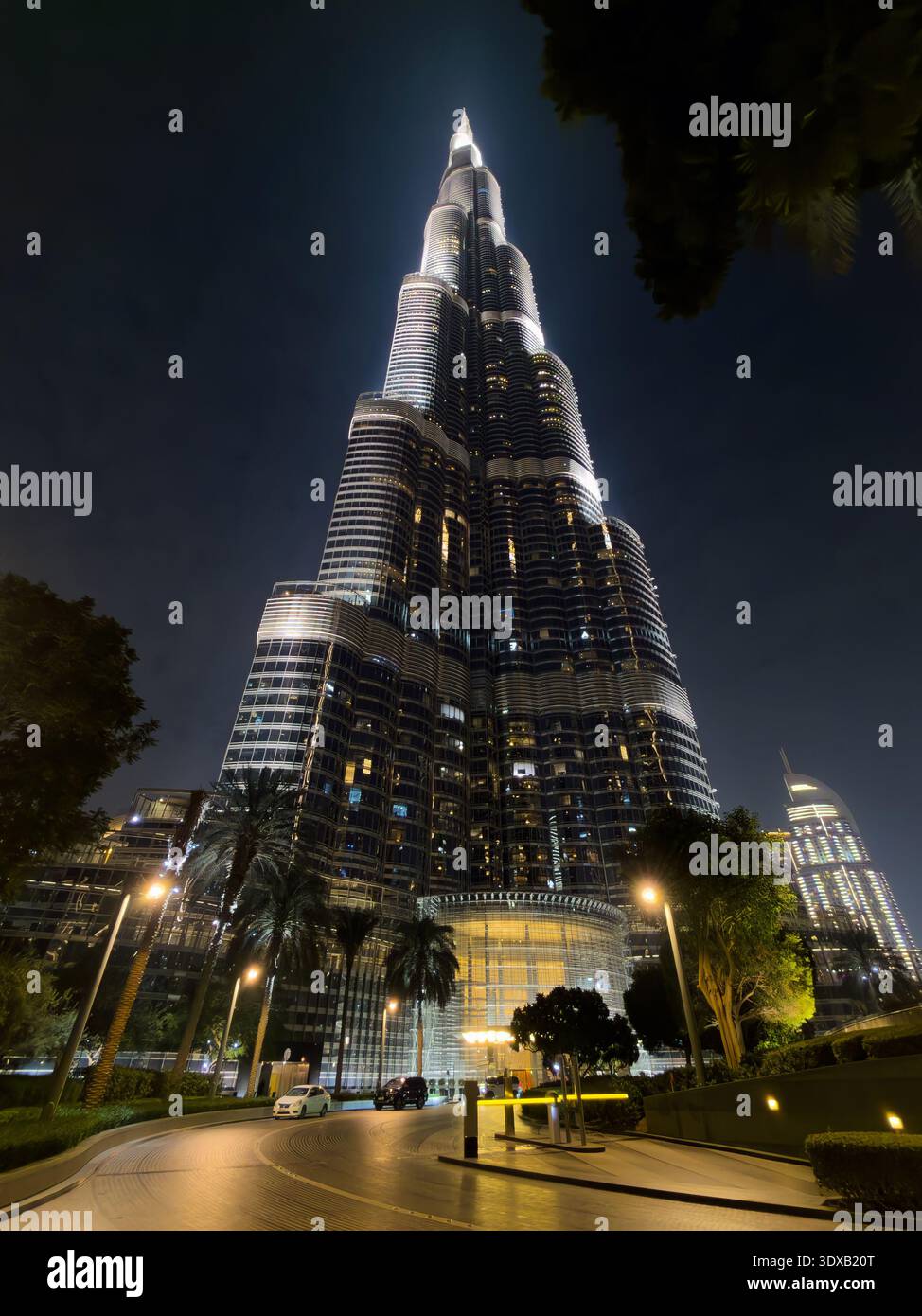 Monumento famoso in tutto il mondo a Dubai, l'iconico grattacielo Burj Khalifa, che risplende su un limpido cielo notturno della città. Foto Stock