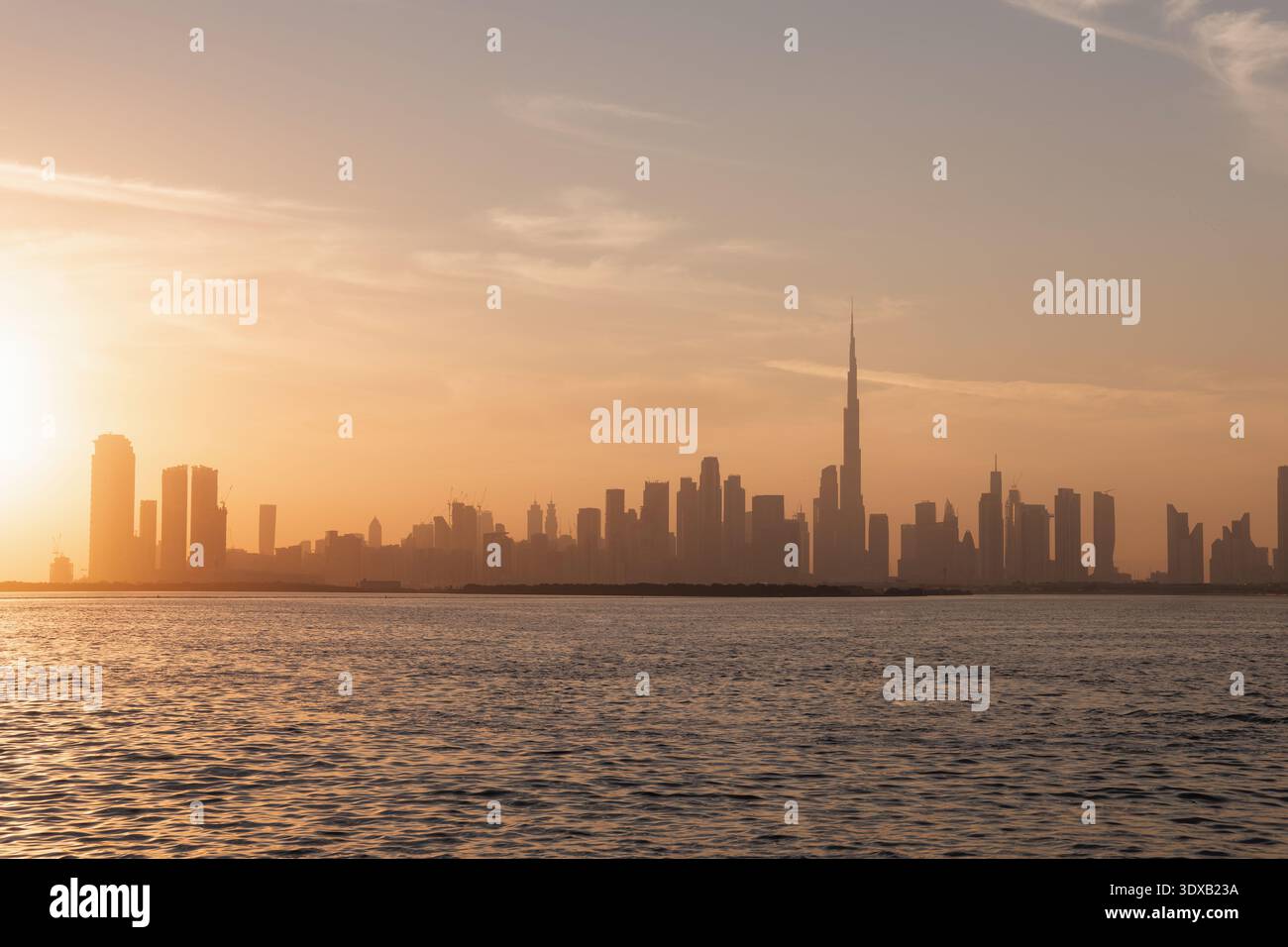 Vista dello skyline della città al tramonto dal Dubai Creek Harbor, futuristici grattacieli e vibrante cielo al tramonto nel deserto. Foto Stock