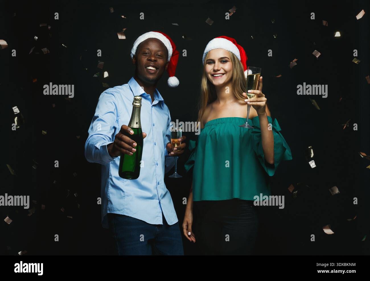 Festeggiamenti per la festa invernale con gli amici che si godono un drink e indossano cappelli festivi Foto Stock
