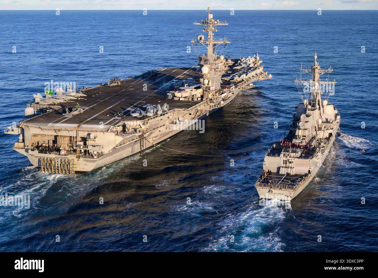La portaerei classe Nimitz USS Theodore Roosevelt (CVN) 71, a sinistra, e il cacciatorpediniere missilistico guidato classe Arleigh Burke USS Carl M. Levin (DDG 120), si preparano per un rifornimento in mare, il 26 novembre 2025, nell'Oceano Pacifico. Theodore Roosevelt, nave ammiraglia del Carrier Strike Group (CSG) 9, sta conducendo esercitazioni per rafforzare la preparazione e la capacità dei gruppi di attacco nell'area delle operazioni della terza flotta statunitense. Solo per uso editoriale. Non per approvazione. Crediti: US Navy / sottufficiale di terza classe Aaron Haro Gonzalez. Foto Stock