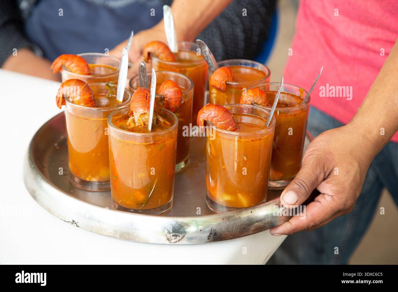 Cocktail di gamberi servito in un bicchiere con salsa dorata, elegante presentazione a base di pesce. Foto Stock