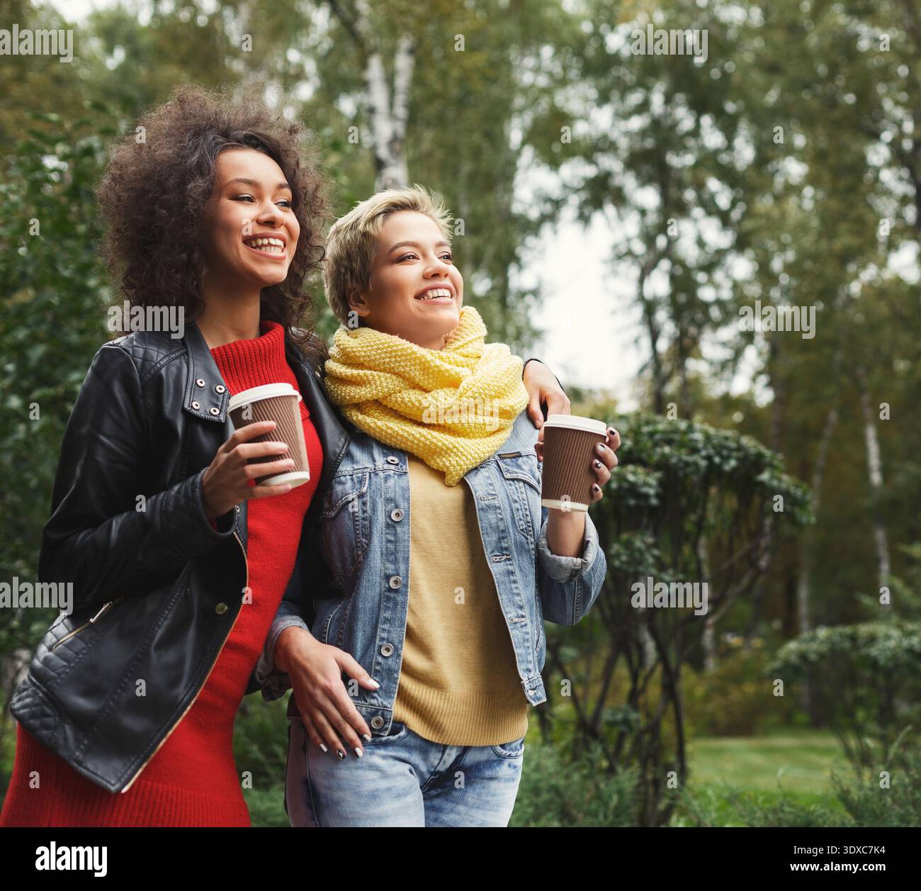 Due amici si gusteranno un caffè in un giardino durante una giornata di sole Foto Stock