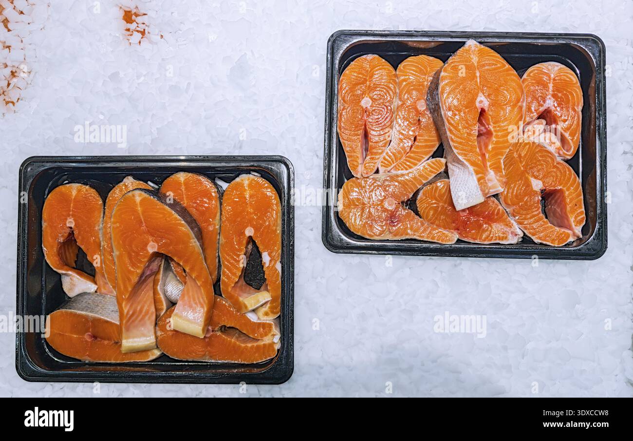 Pezzi di salmone appena tagliati su ghiaccio pronti per la vendita. Foto Stock