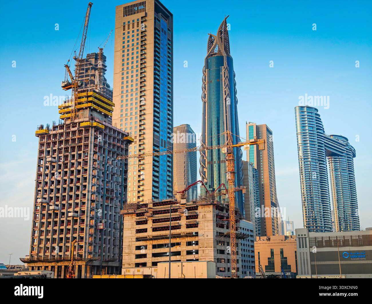 11 30 2025 - Dubai, Emirati Arabi Uniti. Nuovo edificio moderno per uffici a Dubai. Cantiere di grattacieli con gru. Vista aerea con drone Foto Stock