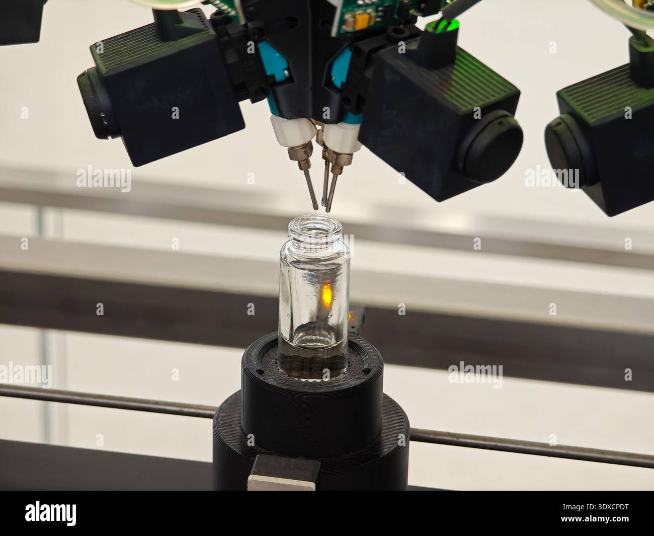 Produzione di profumi. Profumi diversi in bottiglia. Linea di produzione robotizzata di profumi con erogazione automatica di fragranze Foto Stock