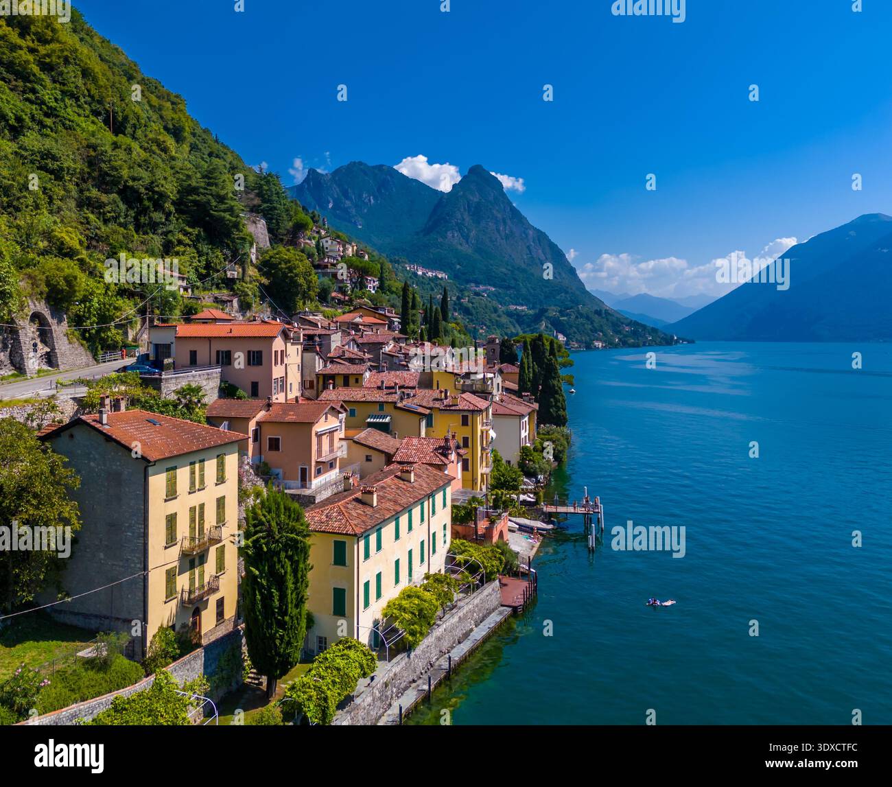 Lago di Lugano, Italia. Vista sul lago, sulle montagne e sul paesino panoramico. Una piccola città italiana sul lago sul confine della Svizzera. Vista aerea con drone Foto Stock
