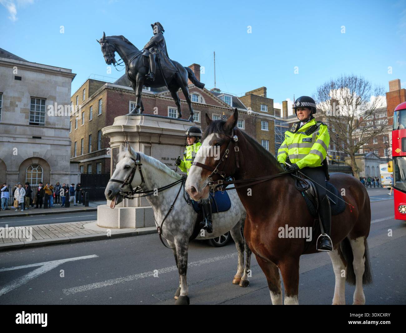 Poliziotti a cavallo che cavalcano per strada a Whitehall, Westminster, Londra, Regno Unito Foto Stock