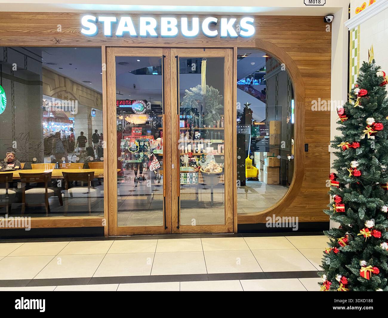 Pattaya, Thailandia - 20 novembre 2025: L'ingresso Starbucks presenta porte in legno e un albero di Natale, creando un'atmosfera calda e invitante per le vacanze Foto Stock