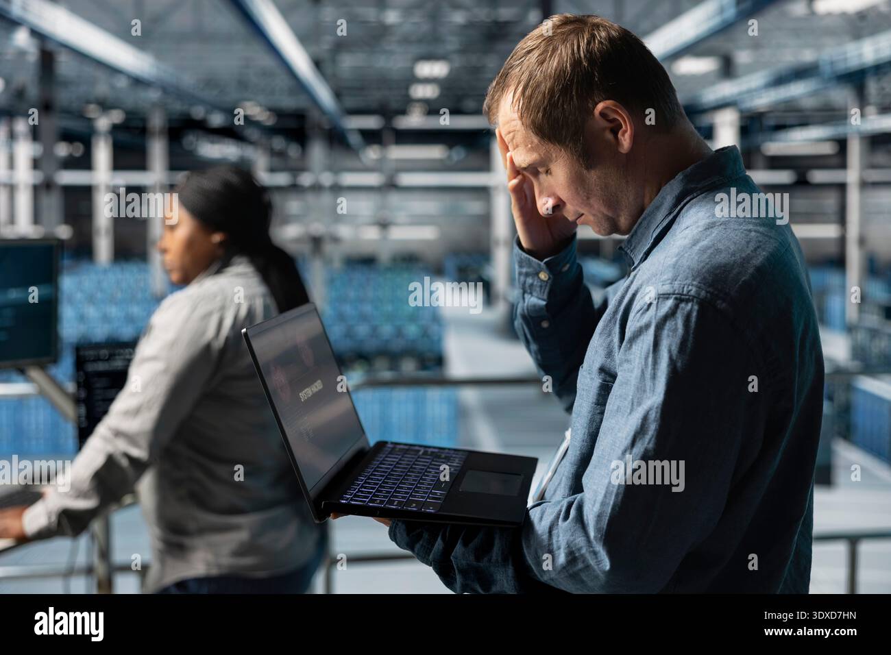 Sviluppatore software del data center turbato dopo aver ricevuto un messaggio di errore critico sul display del notebook. Uomo frustrato nell'hub server avvisato da bug che causano basse prestazioni hardware Foto Stock