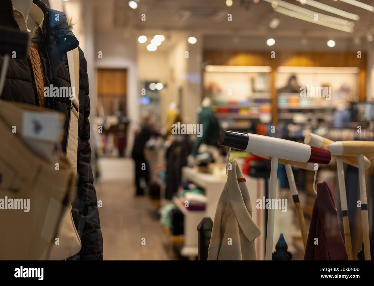 interni boutique di lusso con vista dalla finestra con manichini, abbigliamento firmato e arredi eleganti in un'atmosfera calda e sofisticata Foto Stock
