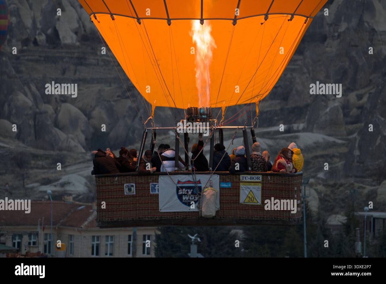 Il pilota accende il bruciatore su una mongolfiera in Cappadocia, Turchia Foto Stock