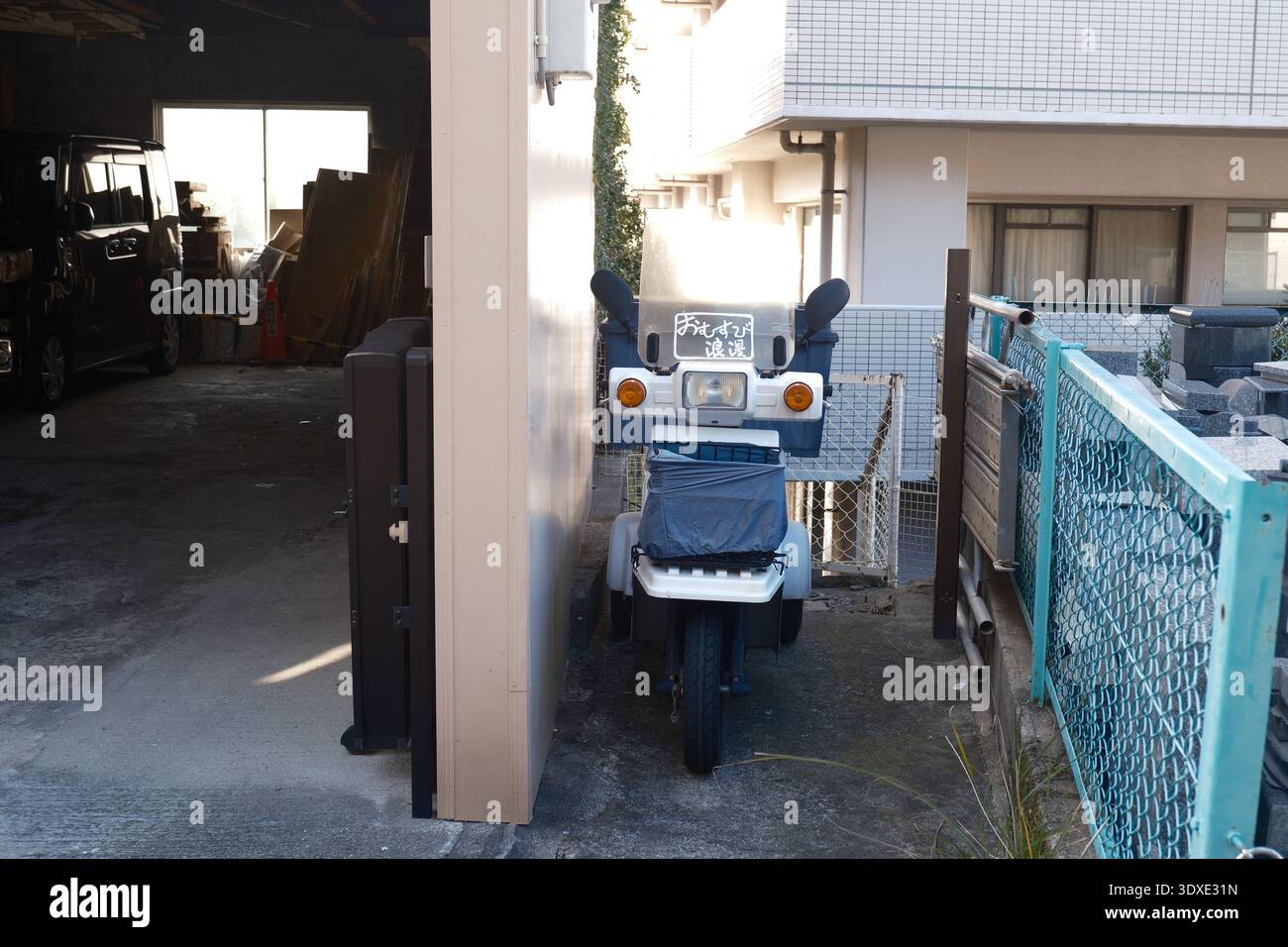 Scooter a tre ruote parcheggiato in uno stretto vicolo residenziale a Nagasaki, in Giappone Foto Stock