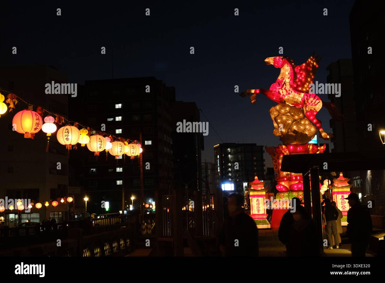 Lanterna a cavallo Pegasus illuminata e lanterne rosse di notte durante il Nagasaki Lantern Festival, Giappone Foto Stock