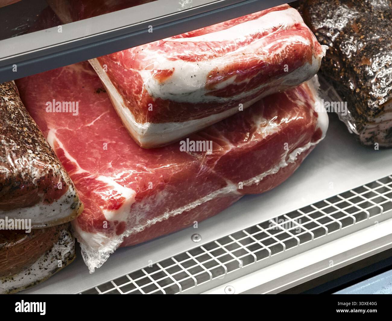 Salati tagli di carne fresca esposti in un'unità frigorifera di macelleria che invitano alla creatività culinaria e alle idee per la preparazione dei pasti Foto Stock