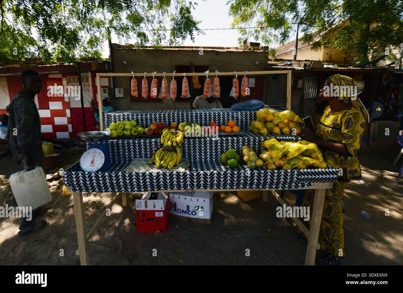 Una donna senegalese che vende frutta in una piccola città a sud di Touba, Senegal. Foto Stock