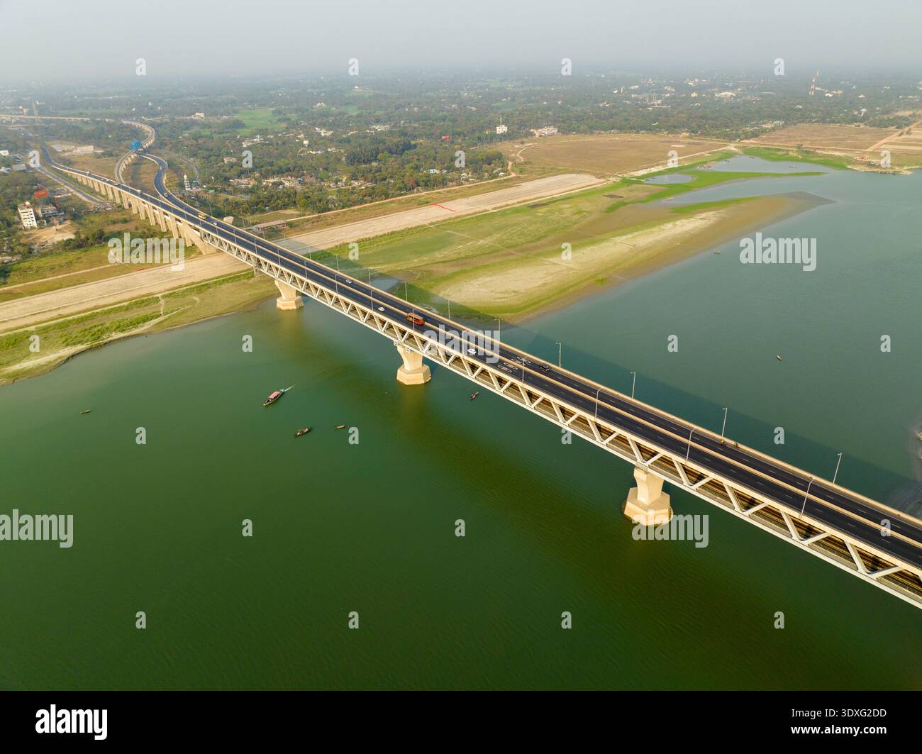 La vista aerea del Padma Bridge si estende attraverso il torbido fiume verde contrastando con le barre di sabbia e i lussureggianti alberi verdi, Mawa, Dhaka Division, Bangl Foto Stock