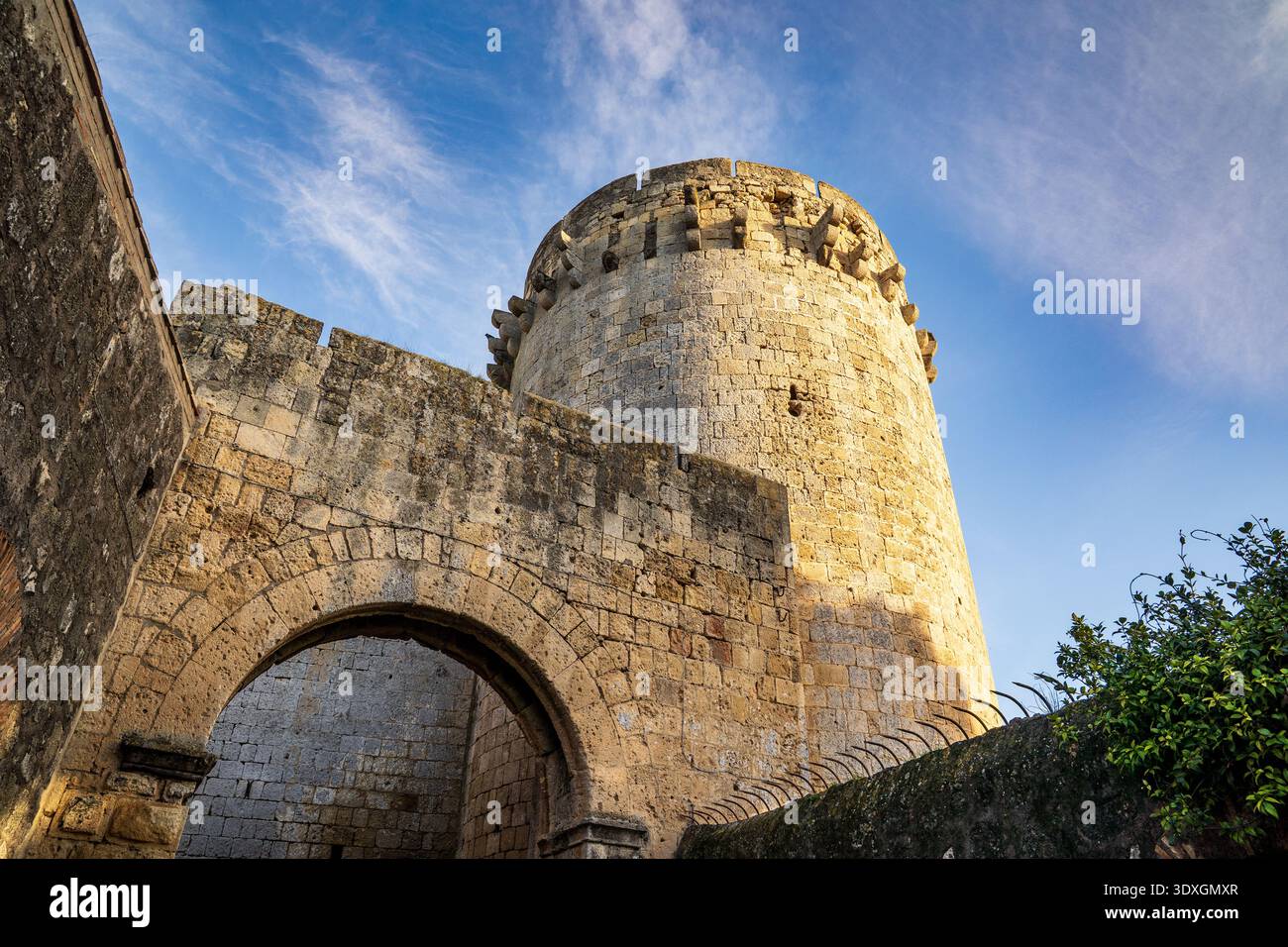 Una suggestiva vista a basso angolo di porta di Castello a Tarquinia, caratterizzata dall'imponente torre circolare di avvistamento del XV secolo. L'immagine evidenzia l'enorme Foto Stock